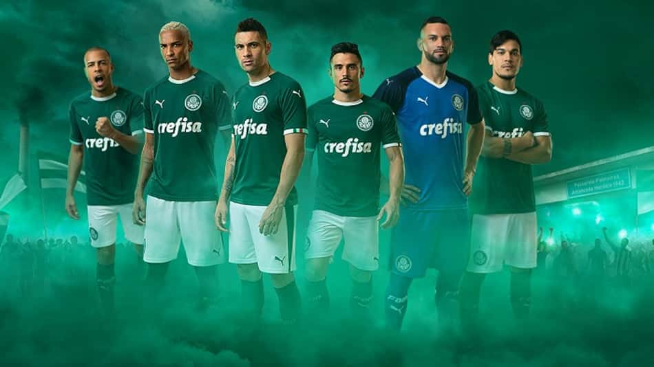 Uniforme principal mantém o verde mais escuro, shorts branco e as meias verdes, além do goleiro em azul