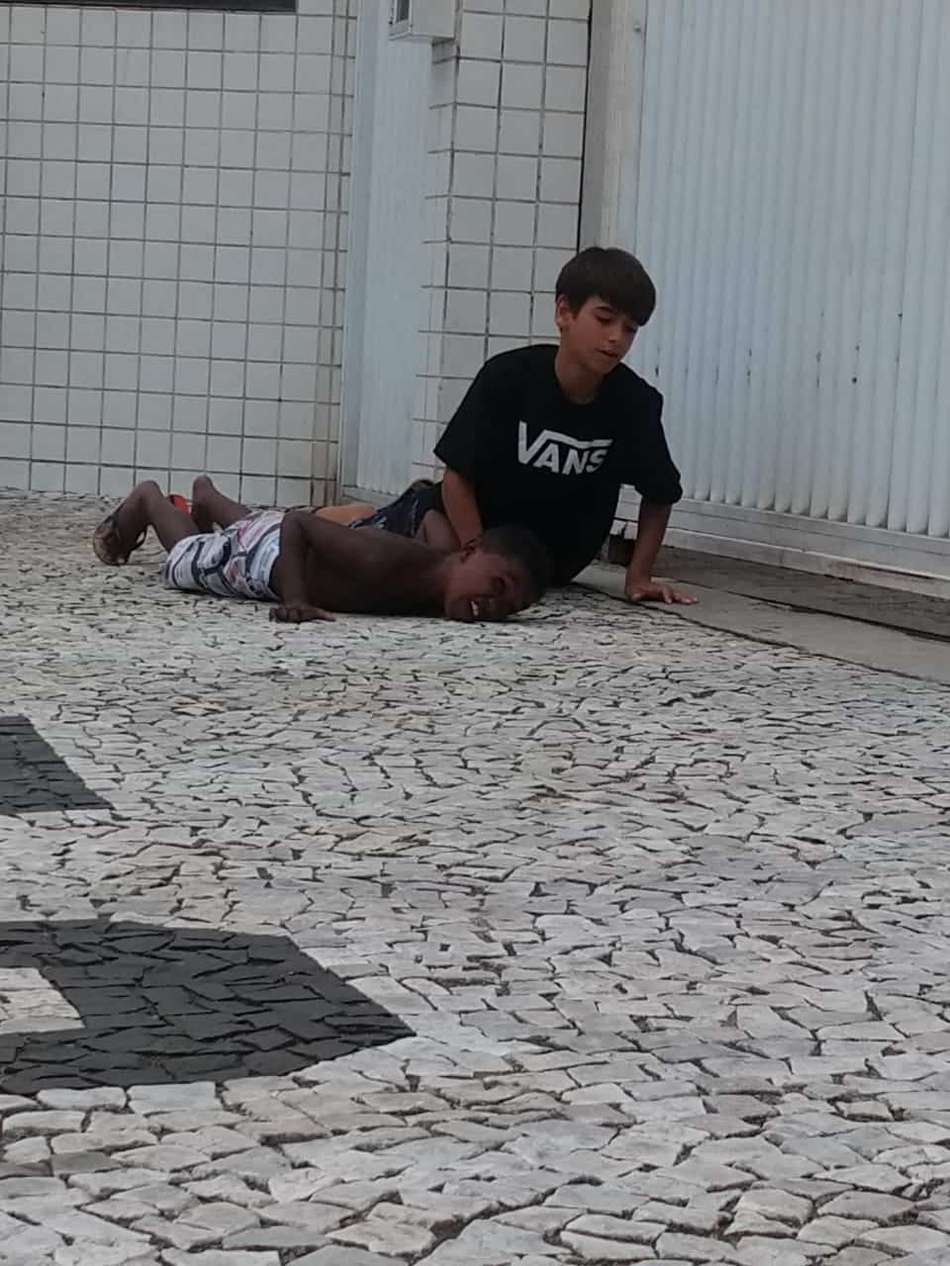 Meninos olham a movimentação do CT Rei Pelé