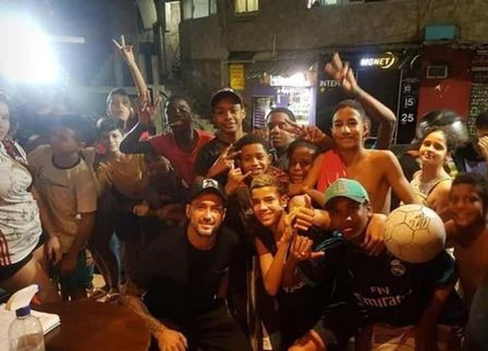 Sem máscara, Arrascaeta, do Flamengo, sobe a favela da Rocinha de moto e bate bola com moradores