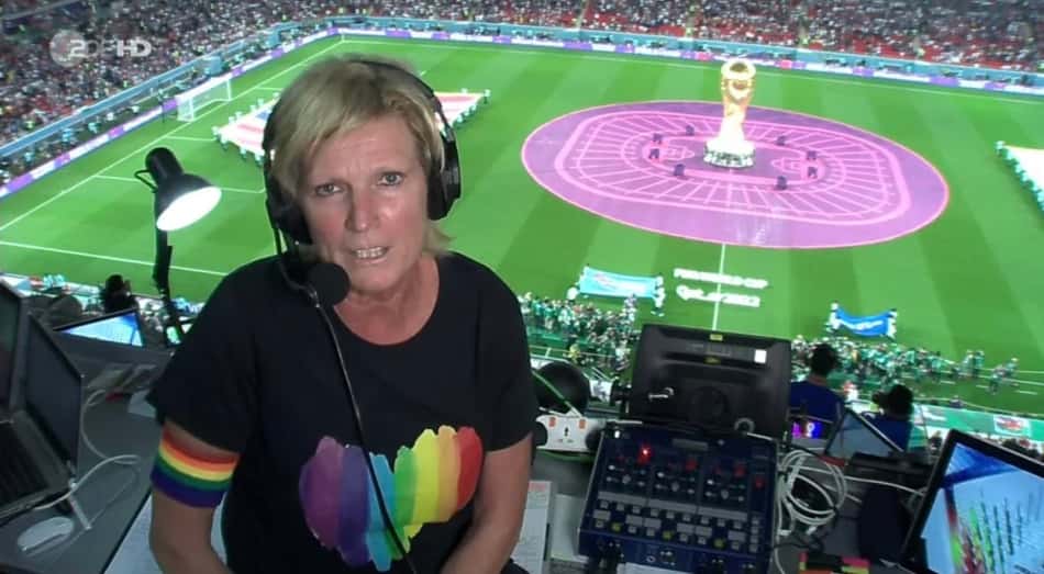 Narradora alemã transmite jogo da Copa vestindo camisa e braçadeira com as cores do arco-íris