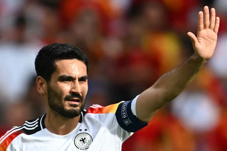 De camisa da Alemanha e com a faixa de capitão, Gundogan estende o braço esquerdo e faz sinal de "espera" em jogo da Eurocopa