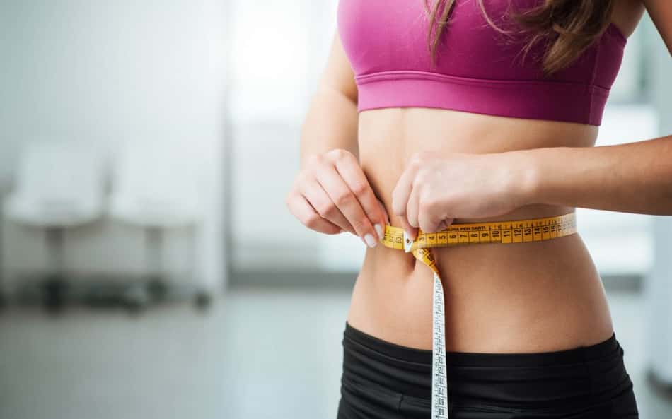 mulher magra com fita métrica na cintura