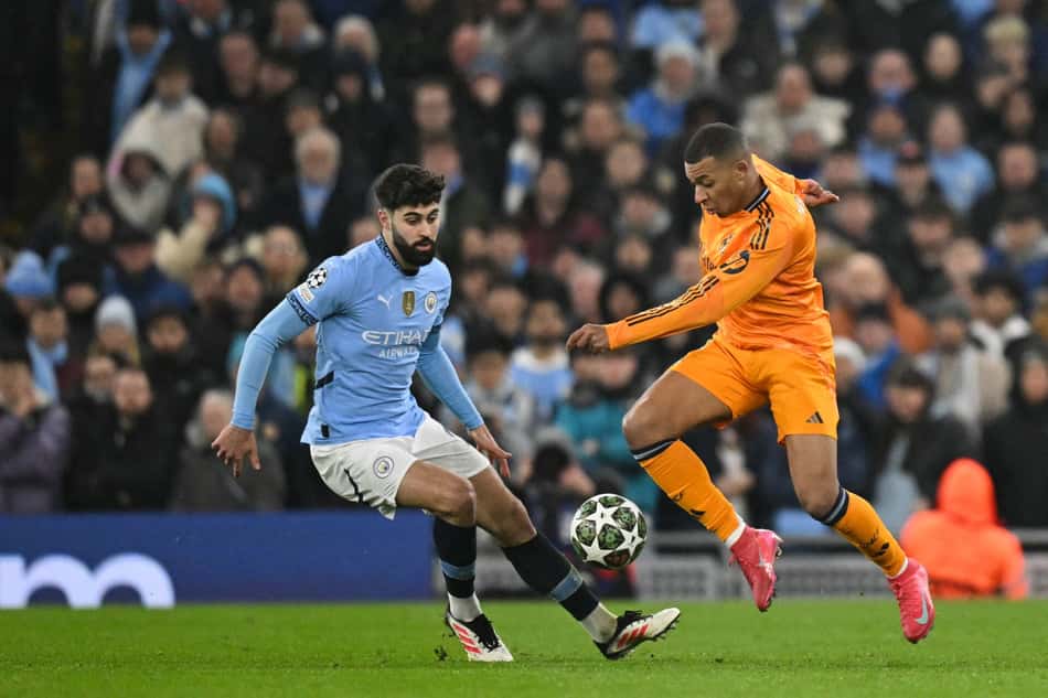 Kylian Mbappé, do Real Madrid, disputa a bola com Joško Gvardiol, do Manchester City, em partida válida Champions League (Foto: Oli Scarff/AFP)