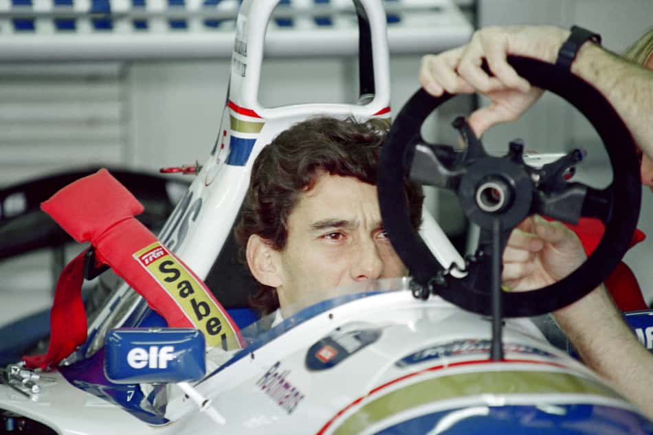 Brazilian F1 driver Ayrton Senna inspects and adjusts the steering wheel in the pits on May 1, 1994 before the start of the San Marino Grand Prix in Imola. Senna died after crashing in the seventh lap. AFP PHOTO JEAN-LOUP GAUTREAU