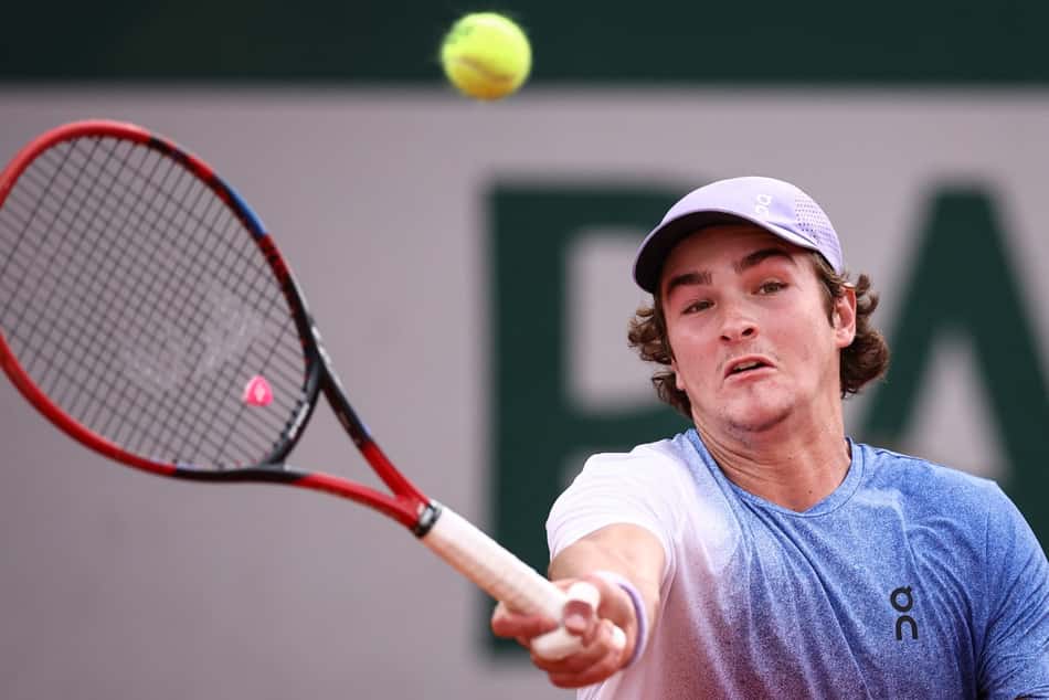 João Fonseca faz um voleio na partida contra o francês Pierre-Hugues Herbert em Roland Garros (Photo by Anne-Christine POUJOULAT / AFP)