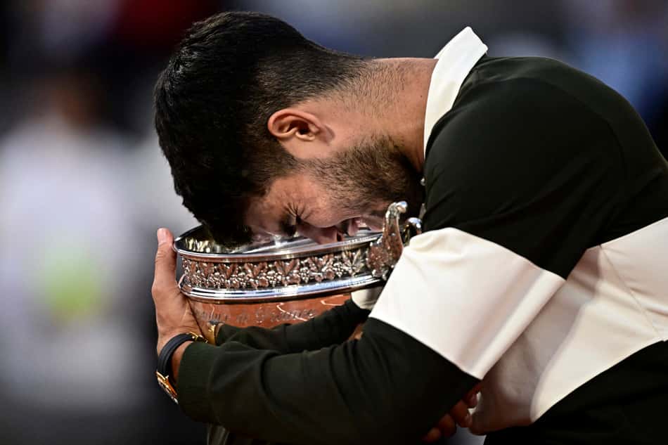 O espanhol Carlos Alcaraz segura o troféu de Roland Garros (Foto: JULIEN DE ROSA / AFP)