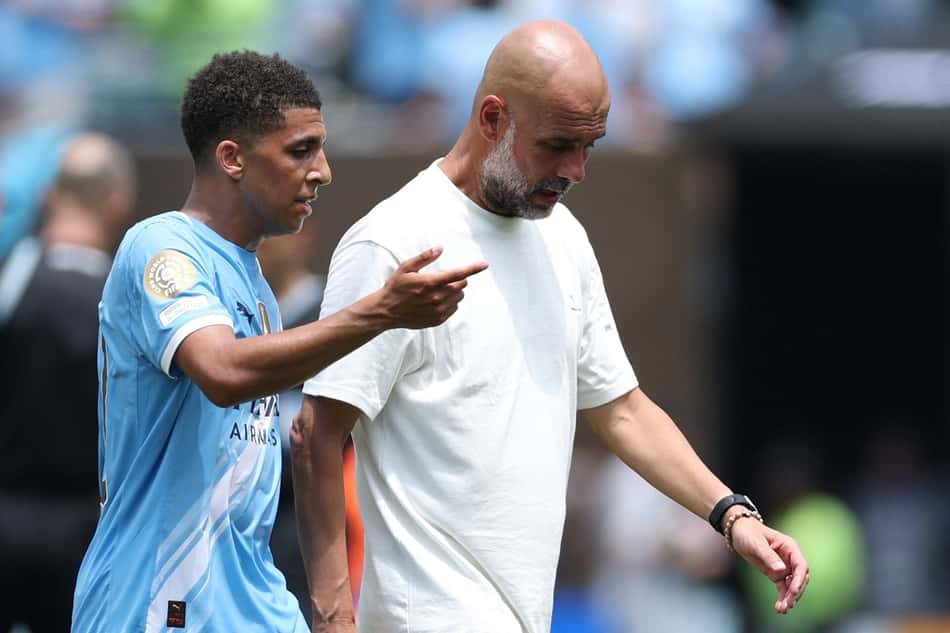 Pep Guardiola conversa com Rico Lewis, expulso posteriormente, durante o intervalo (Foto: Charly Triballeu/AFP)