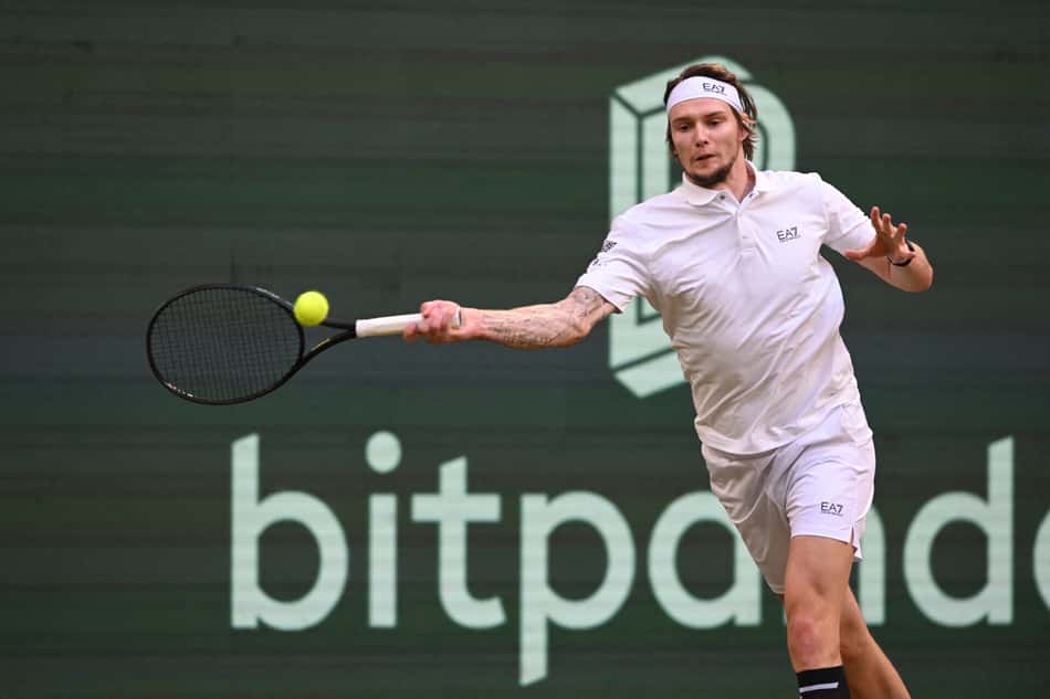 O italiano Jannik Sinner joga a bola para o cazaque Alexander Bublikin na partida de simples masculina de tênis durante o torneio de tênis Halle Open ATP em Halle, em 19 de junho de 2025. (Foto de CARMEN JASPERSEN / AFP)