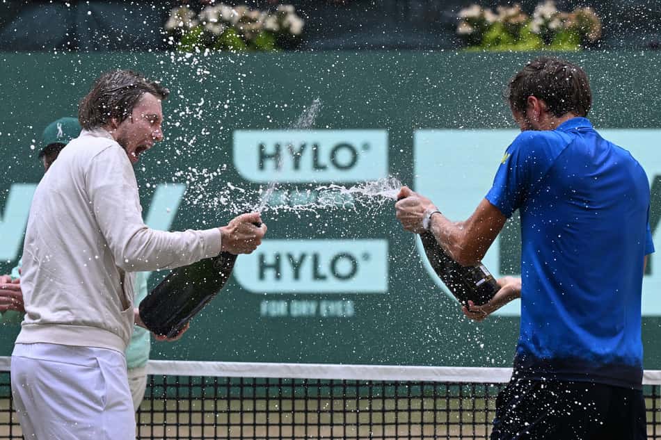 O cazaque Alexander Bublik (e) e o russo Daniil Medvedev celebram com champanhe após a final do ATP de Halle (Foto: CARMEN JASPERSEN / AFP)