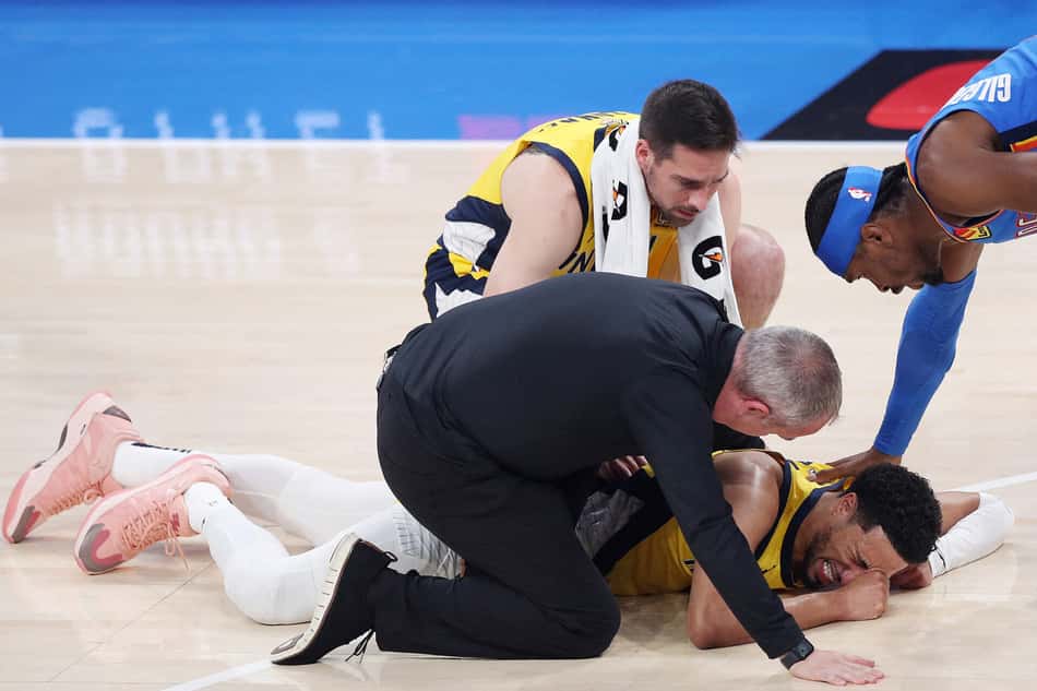 OKLAHOMA CITY, OKLAHOMA - JUNE 22: Tyrese Haliburton #0 of the Indiana Pacers sustains an injury during the first quarter as Shai Gilgeous-Alexander #2 of the Oklahoma City Thunder checks on him in Game Seven of the 2025 NBA Finals at Paycom Center on June 22, 2025 in Oklahoma City, Oklahoma. NOTE TO USER: User expressly acknowledges and agrees that, by downloading and or using this photograph, User is consenting to the terms and conditions of the Getty Images License Agreement.   Justin Ford/Getty Images/AFP (Photo by Justin Ford / GETTY IMAGES NORTH AMERICA / Getty Images via AFP)