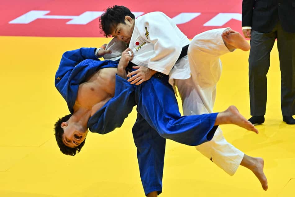 O japonês Ryuju Nagayama luta contra Ruan Poltoratskii. de Brunei (azul), na categpria -60kg masculina (foto: Attila KISBENEDEK / AFP)