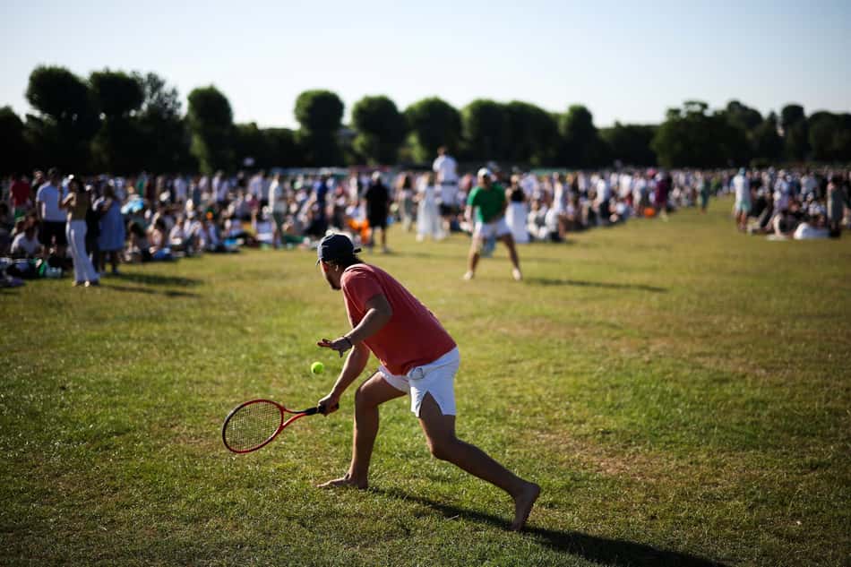 Torcedores jogam tênis enquanto fazem fila para conseguir ingressos no primeiro dia de Wimbledon (foto: HENRY NICHOLLS / AFP)