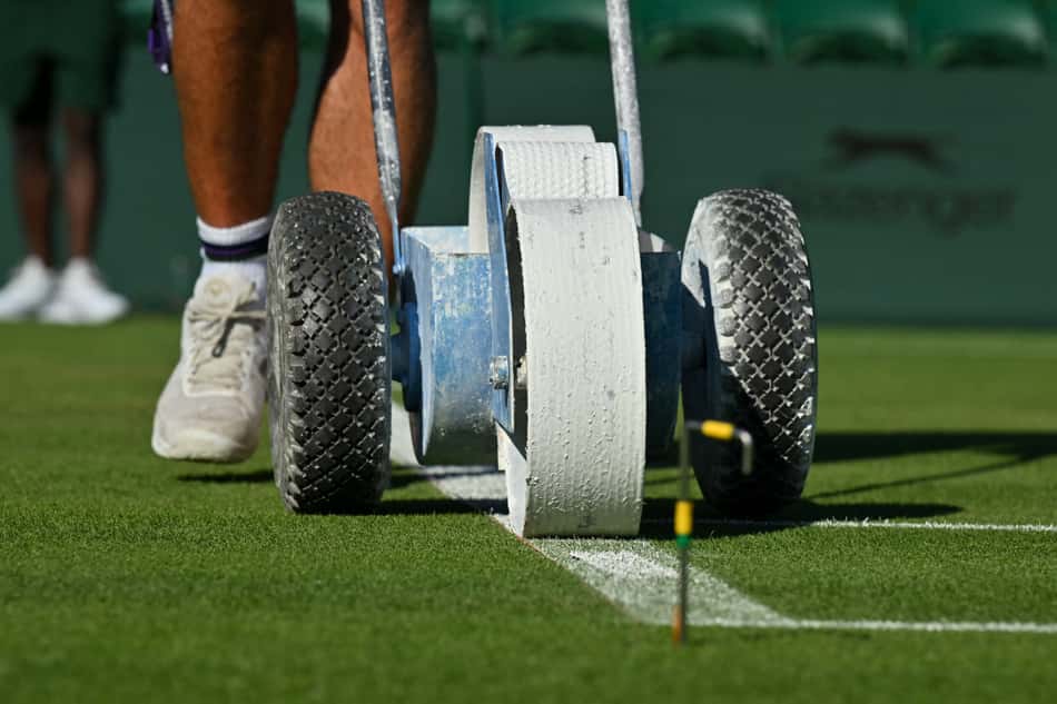 Linhas de uma quadra sendip pintadas no primeiro dia de Wimbledon (foto: Glyn KIRK / AFP)