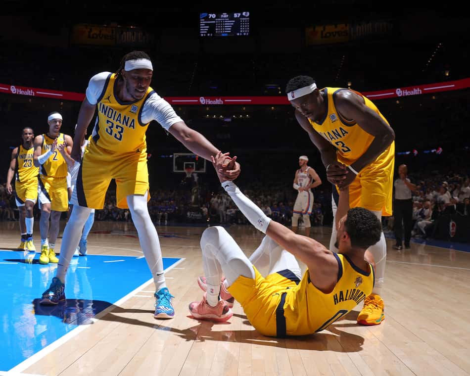 Myles Turner e Pascal Siakam ajudam Tyrese Haliburton durante jogo entre Pacers e Thunder pelas finais da NBA (Foto: Nathaniel S. Butler/NBAE via Getty Images/AFP)