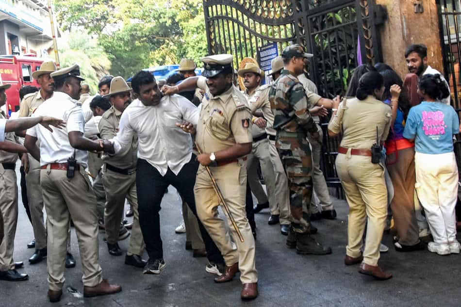 Seguranças tentam cnter os trocedores do lado de fora do Chinnaswamy Stadium em torneio de críquete (foto: AFP)