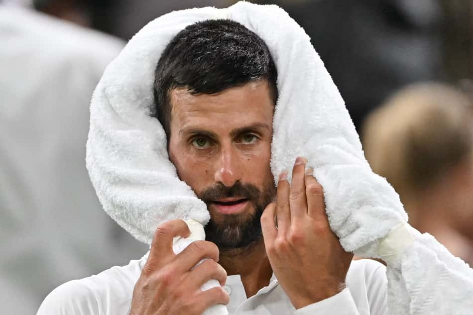 O sérvio Novak Djokovic usa uma toalha na vitória sobre o francês Alexandre Muller em Wimbledon (Foto: Glyn KIRK / AFP)