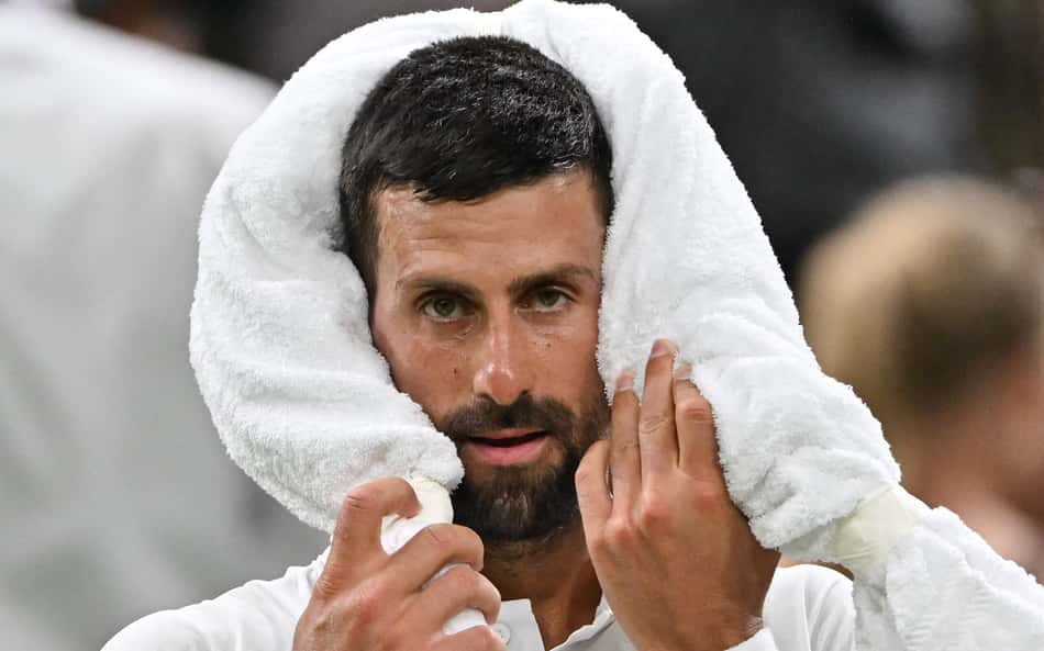 O sérvio Novak Djokovic usa uma toalha na vitória sobre o francês Alexandre Muller em Wimbledon (Foto: Glyn KIRK / AFP)