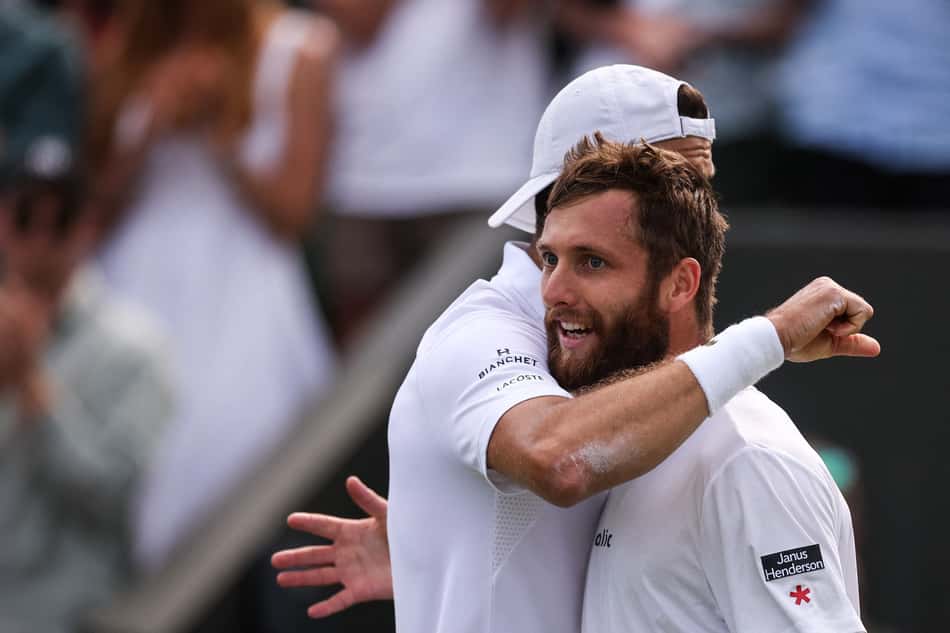 O búlgaro Grigor Dimitrov (e) abraça o francês Corentin Moutet após a vitória em Wimbledon (Fto: HENRY NICHOLLS / AFP)