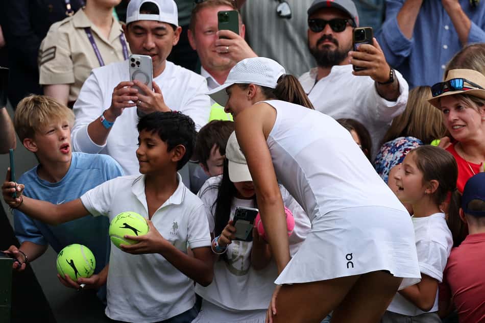 A polonesa Iga Swiatek posa com torcedores após nova vitória em Wimbledon (Foto: Adrian Dennis / AFP)