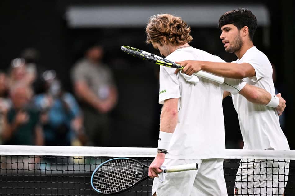 O espanhol Carlos Alcaraz abraça o russo Andrey Rublev após a vitória em Wimbledon (Foto: Kirill KUDRYAVTSEV / AFP)