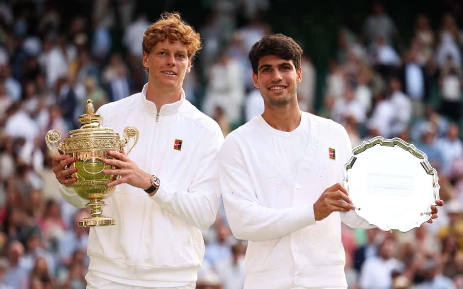 O italiano Jannik Sinner e o espanhol Carlos Alcaraz com os troféus de Wimbledon (Foto: HENRY NICHOLLS / AFP)