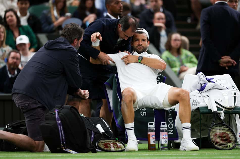 Búlgaro Grigor Dimitrov recebe tratamento médico antes de abandonar a partida contra Jannik Sinner em Wimbledon (foto: Adrian Dennis / AFP)