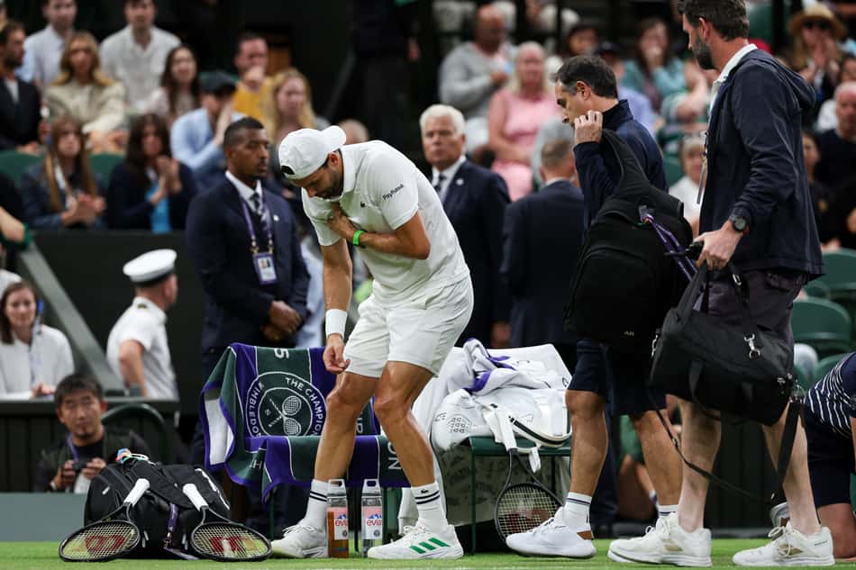 Grigor Dimitrov dente dores antes de abandonar a partida contra Jannik Sinner em Wimbledon (foto: Adrian Dennis / AFP)