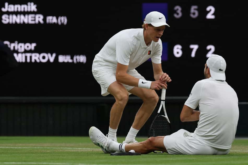 Grigor Dimitrov recebe tratamento médico antes de abandonar a partida contra Jannik Sinner em Wimbledon (foto: Adrian Dennis / AFP)