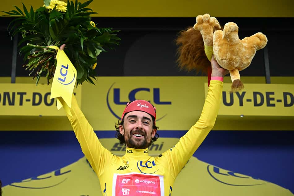 O piloto irlandês da equipe EasyPost, Ben Healy, comemora no pódio com a camisa amarela de líder geral após a 10ª etapa da 112ª edição da Tour de France 2025 (foto: Loic VENANCE / AFP)