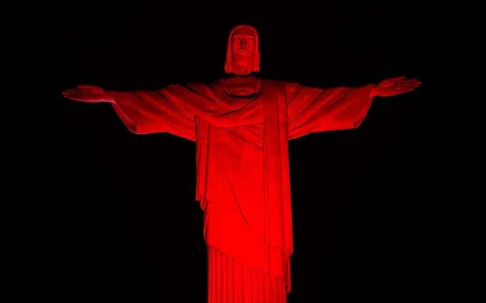 Cristo Redentor fica vermelho em homenagem a tour do Bayer pelo Rio de Janeiro