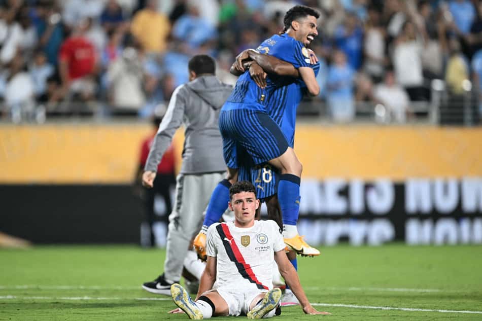 Phil Foden reage enquanto jogadores do Al-Hilal comemoram a vitória sobre o Manchester City, em partida válida pelas oitavas de final do Mundial de Clubes (Foto: Patricia de Melo Moreira/AFP)