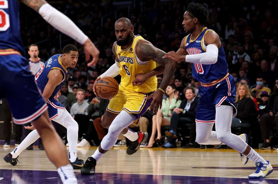 LeBron James, do Lakers, em disputa contra Jonathan Kuminga, do Warriors, pela NBA (Foto: AFP)