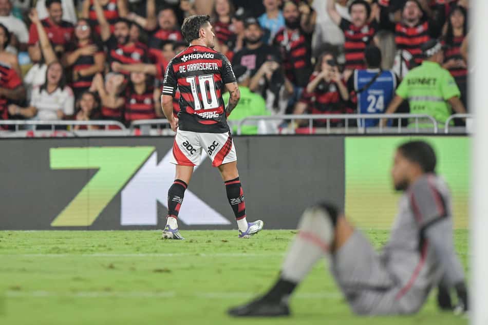 Arrascaeta comemora gol do Flamengo diante de um Lucas Arcanjo abatido (Foto: Thiago Ribeiro/AGIF)