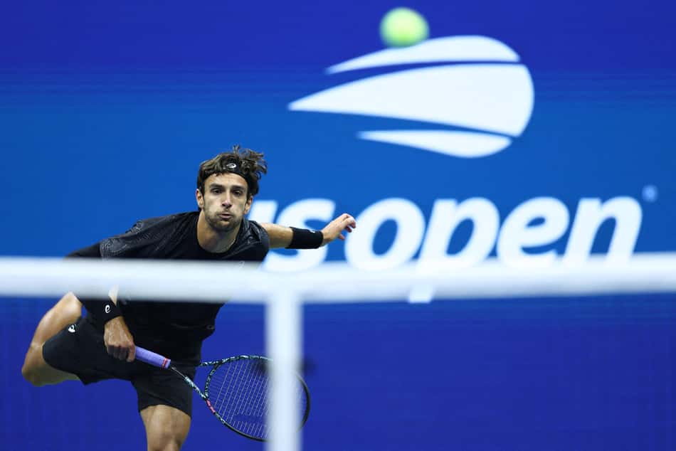 O italiano Lorenzo Musetti devolve a bola na partida contra o compatriota Jannik Sinner no US Open (Foto: CHARLY TRIBALLEAU / AFP)