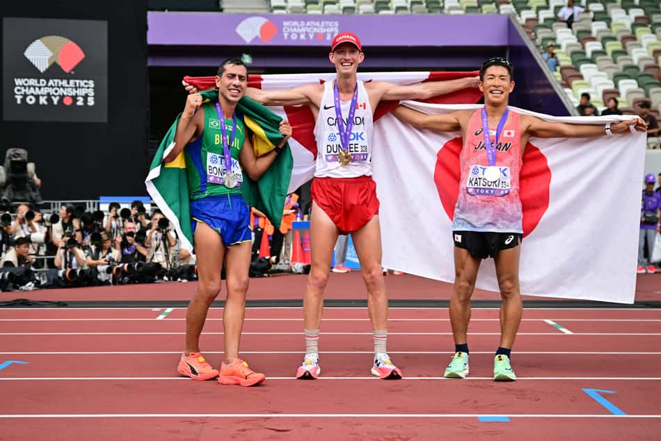 (L-R) Silver medallist Brazil's athlete Caio Bonfim, gold medallist Canada's athlete Evan Dunfee, and bronze medallist Japan's athlete Hayato Katsuki celebrate following the men's 35km race walk final during the World Athletics Championships in Tokyo on September 13, 2025. (Photo by Ben STANSALL / AFP)