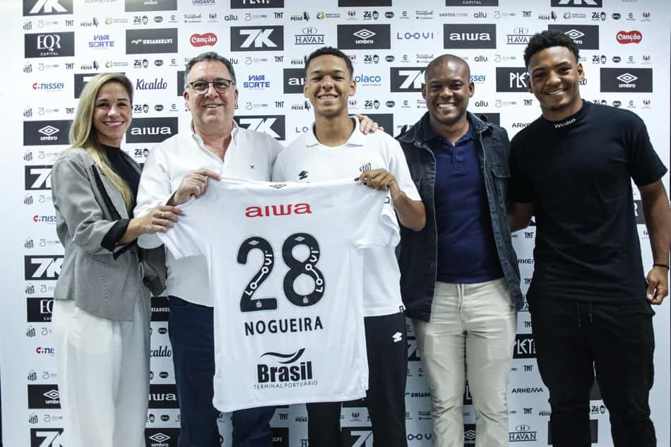 David Nogueira assina o primeiro contrato profissional ao lado da família e do presidente Marcelo Teixeira. (Foto: Reinaldo Campos/Santos FC)