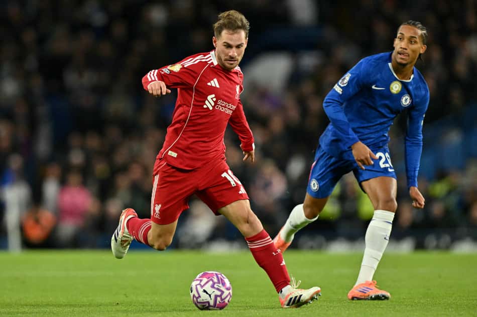 Mac Allister conduz a bola e é observado por João Pedro em Chelsea x Liverpool