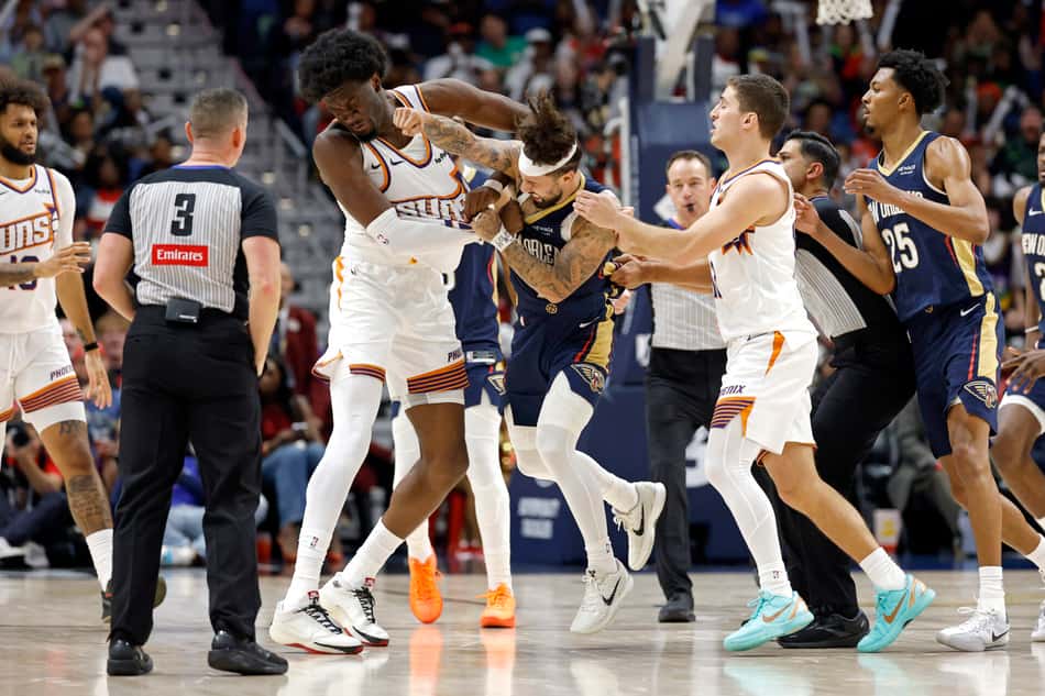 Alvarado (azul) acerta soco em Williams (branco) em partida entre Pelicans x Suns