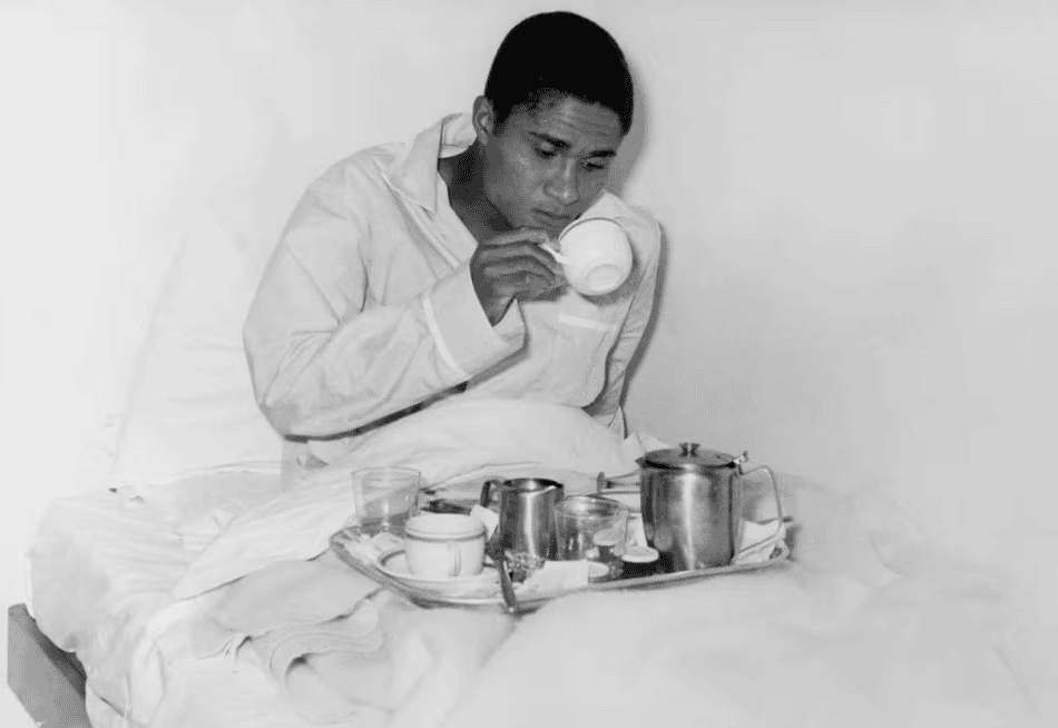 Eusébio bebe xícara deitado em uma cama