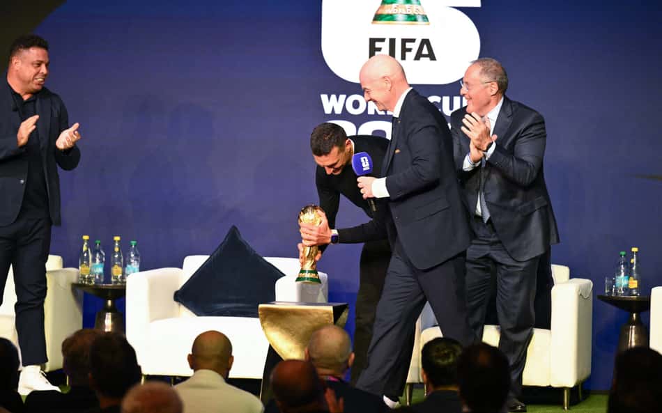 A convite de Infantino, Scaloni segura o troféu da Copa do Mundo; agora, sem luvas