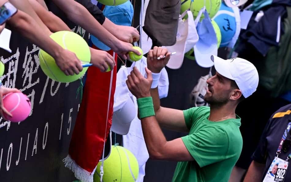 Novak Djokovic autografa bola de fã no Australian Open (Foto: William WEST / AFP)