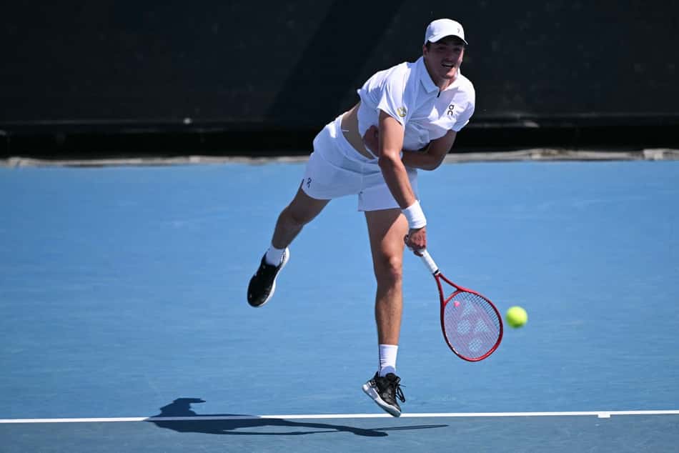 João Fonseca saca na estreia do Australian Open contra o americano Eliot Spizzirri (Foto: WILLIAM WEST / AFP)