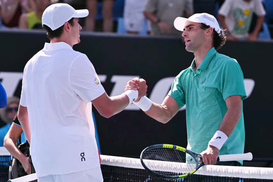 Eliot Spizzirri é cumprimentado por João Fonseca após a vitória no Australian Open (Foto: WILLIAM WEST / AFP)