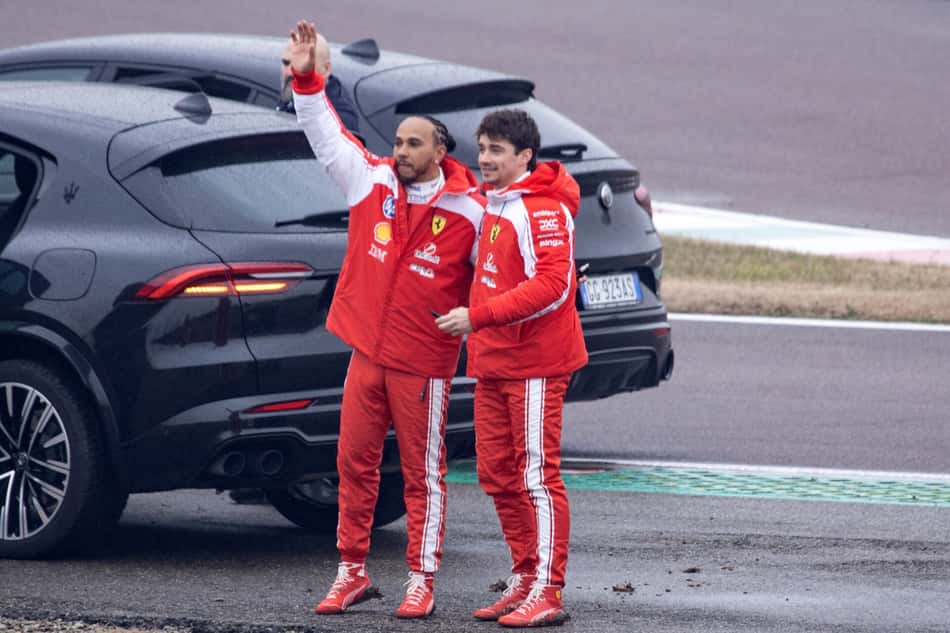 Lewis Hamilton e Charles Leclerc acenam para fãs após testarem a nova Ferrari SF-26 em Fiorano, em 23 de janeiro de 2026 (Foto: Federico Scoppa/AFP)