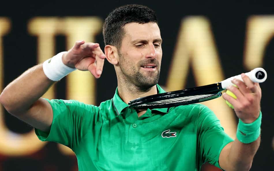 Novak Djokovic imita tocar violino com a raquete ao comemorar a vitória sobre o holandês Botic van de Zandschulp no sétimo dia do Australian Open, em Melbourne, em 24 de janeiro de 2026 (Foto: Martin Keep/AFP)