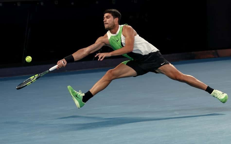 O espanhol Carlos Alcaraz devolve a bola na partida contra o australiano Alex De Minaur no Australian Open (Foto: IZHAR KHAN / AFP)