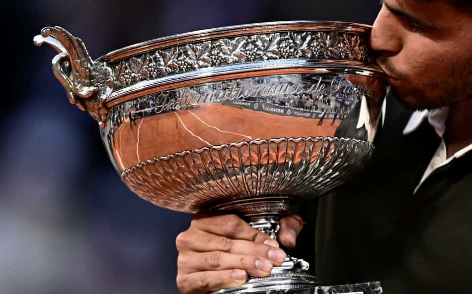 O espanhol Carlos Alcaraz beija o troféu de Roland Garros (Foto: JULIEN DE ROSA / AFP)
