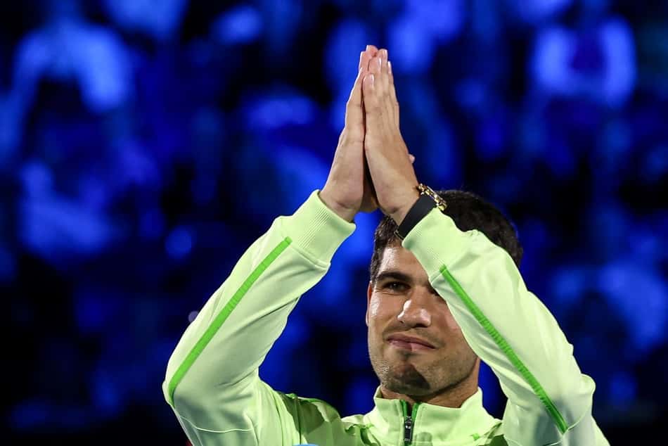 O espanhol Carlos Alcaraz agradece ao público após derrotar o sérvio Novak Djokovicna final do Australian Open (Foto: IZHAR KHAN / AFP)