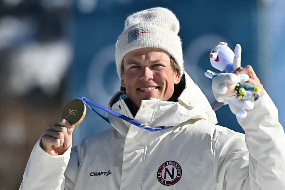 O norueguês Johannes Høsflot Klæbo celebra o ouro no pódio dos 10km livre com largada intervalada do esqui cross-country, no Estádio de Esqui Cross-Country de Tesero, nos Jogos Olímpicos de Inverno Milano Cortina 2026, em 13 de fevereiro de 2026. (Foto: Javier Soriano/AFP)