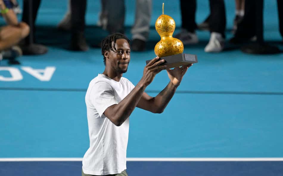 O francês Gael Monfils ergue troféu em homenagem aos 20 anos de participação no ATP 500 do México 2026, na Arena GNP Seguros, em Acapulco, em 26 de fevereiro de 2026 (Foto: Alfredo Estrella/AFP)